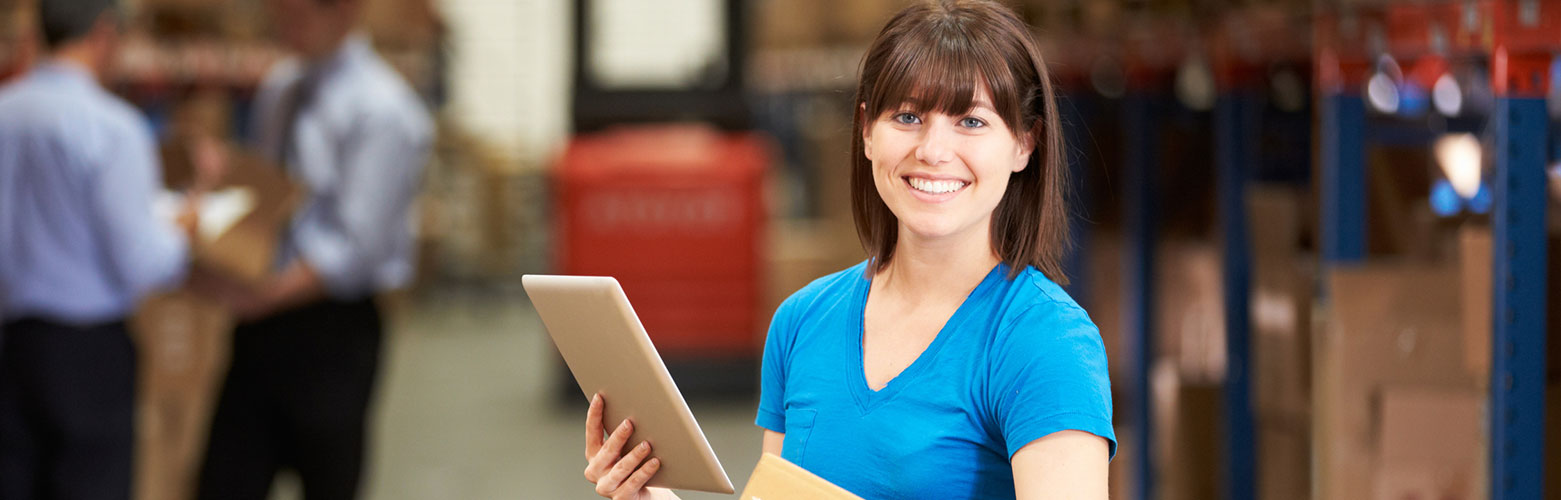 Worker in Warehouse checking Boxes using digital Tablet